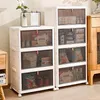 A set of white, stackable storage boxes with transparent doors, arranged in a room. Voir les images du produit