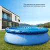 An inflatable pool covered with a blue tarp is situated on a grassy lawn in front of a modern house. Podgląd zdjęcia produktu