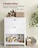A white bathroom cabinet with two drawers and an open shelf, displaying various toiletries and decorative items. A woven basket is placed next to the cabinet. Náhľad obrázku produktu