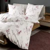 A neatly made bed with floral patterned bedding. Produktbild-Vorschau