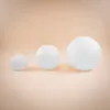 Three white spheres of varying sizes are arranged in a row on a light peach background. Produktbild-Vorschau