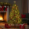 A decorated Christmas tree with presents underneath, in front of a fireplace with stockings hanging. Produktbild-Vorschau