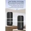 Two black cylindrical speakers are shown in a serene, watery environment with a sandy background. Produktbild-Vorschau