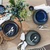 A table setting with plates, cutlery, and a floral arrangement. Podgląd zdjęcia produktu