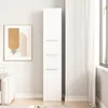 A tall, white storage cabinet with three doors is shown in a room with a framed abstract art piece on the wall and a white sofa. Podgląd zdjęcia produktu
