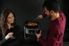 A couple enjoying wine while cooking with a slow cooker. Anteprima dell’immagine prodotto