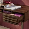 A close-up view of a wooden desk with an open drawer, revealing some items inside. Anteprima dell’immagine prodotto