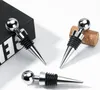 Three chrome wine stoppers with black rubber seals are arranged on a white surface, with one partially resting on a black box and another next to a cork. Produktbild-Vorschau