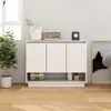 A white sideboard with three doors and an open shelf below, decorated with a plant, a basket, and a clock. It is placed on a wooden floor in front of a light gray wall and a window. Anteprima dell’immagine prodotto