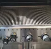 Close-up of a stainless steel grill with multiple control knobs. Anteprima dell’immagine prodotto