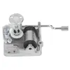 A close-up studio shot of a music box mechanism. Voir les images du produit