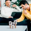 Two men are sitting on a couch and a table in front of them has three cards with letters A, B, and C on them. Voir les images du produit