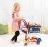 A young girl is playing with a toy shopping cart filled with toy groceries. Produktbild-Vorschau