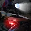 A close-up view of the rear of an electric bicycle, showing the seat and tail light, with the front headlight illuminated. Produktbild-Vorschau