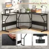 A black L-shaped desk with a monitor stand and keyboard is shown in a room with a window and a rug. Anteprima dell’immagine prodotto