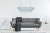 A modern living room with a gray sofa, a crystal chandelier, and a framed artwork. Podgląd zdjęcia produktu