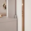 A close-up view of a corner of a vanity or dresser, showing a small metallic detail and a hint of a drawer front. Produktbild-Vorschau