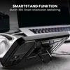A black phone case with a kickstand is shown on a table next to headphones and a laptop. Produktbild-Vorschau