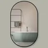 A bathroom with a bathtub and a towel rack reflected in an oval mirror. Produktbild-Vorschau