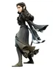 A vinyl figurine of a female character with pointed ears, wearing a dark dress and boots, posed in a dynamic stance against a white background. Náhled obrázku produktu