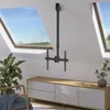 A TV ceiling mount is installed on a sloped ceiling in a room with skylights, a plant, and a media console. Produktbild-Vorschau