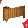 A wooden garden border laid out in a curve and partially rolled up. Produktbild-Vorschau