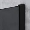 A close-up view of the corner of a black shower wall panel against a textured gray concrete wall. Produktbild-Vorschau