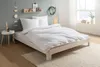 A neatly made bed with white bedding in a bedroom setting. Produktbild-Vorschau