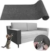 A rolled-up piece of gray felt material is shown above a gray and light gray sofa. A small cat is shown on the left, reaching up towards the sofa armrest, which is covered in the gray felt material. A circular inset on the right shows hands cutting the fel Produktbild-Vorschau