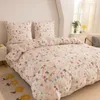 A neatly made bed with a floral and rabbit-patterned duvet cover and pillows. Produktbild-Vorschau