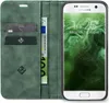 A green flip case for a Samsung Galaxy S7 phone, showing the inside with card slots and a banknote, and the phone screen displaying the time and date. Produktbild-Vorschau