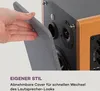 A hand is shown removing a grey cover from a speaker. Produktbild-Vorschau