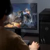 A person wearing headphones plays a video game on a computer. Podgląd zdjęcia produktu