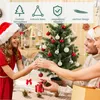 A family decorating a small Christmas tree indoors. Produktbild-Vorschau