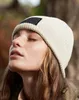 A close-up shot of a woman wearing a beanie in an outdoor setting. Anteprima dell’immagine prodotto
