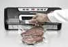 A hand is shown using a vacuum sealer machine to seal a bag of raw meat on a metallic surface. Produktbild-Vorschau