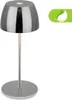 A modern, cordless LED table lamp with a chrome finish is presented against a white background. A green leaf icon is visible in the upper right corner. Produktbild-Vorschau