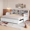 A white daybed with drawers and a bookshelf headboard, set up in a bedroom with decorative pictures on the wall and a rug on the floor. Náhled obrázku produktu