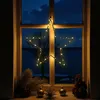A star-shaped LED light decoration hangs in a window at night, with a dark, cloudy sky and water visible outside. Decorative items are placed on the windowsill. Produktbild-Vorschau