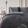A close-up view of a dark gray duvet cover and pillow on a bed. Náhled obrázku produktu