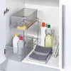 A metal mesh shelving unit with cleaning supplies inside, placed in a cabinet. Produktbild-Vorschau