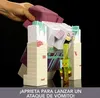 A hand is shown pressing down on a purple toy, causing a yellow liquid to be ejected from a Minecraft-themed toy monster. Náhled obrázku produktu