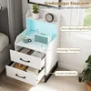 A white nightstand with drawers and shelves, illuminated by blue LED lights, placed next to a bed. Anteprima dell’immagine prodotto