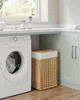 A laundry room with a washing machine, a wicker laundry basket, and cabinets. Podgląd zdjęcia produktu