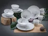 A set of white porcelain dinnerware with a floral design, arranged on a neutral background with decorative elements. Náhľad obrázku produktu