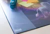 A close-up shot of a desk mat with a unicorn design, featuring a blue stapler and sticky notes. Náhľad obrázku produktu