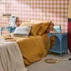 A bedroom scene with a bed, nightstands, and a surfboard. Produktbild-Vorschau