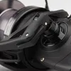 A close-up view of a black fishing reel handle and spool. Produktbild-Vorschau