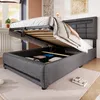 A bed with its storage compartment open, revealing stored items, in a bedroom setting. Produktbild-Vorschau