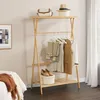 A wooden garment rack with clothes and accessories displayed in a room setting. Podgląd zdjęcia produktu